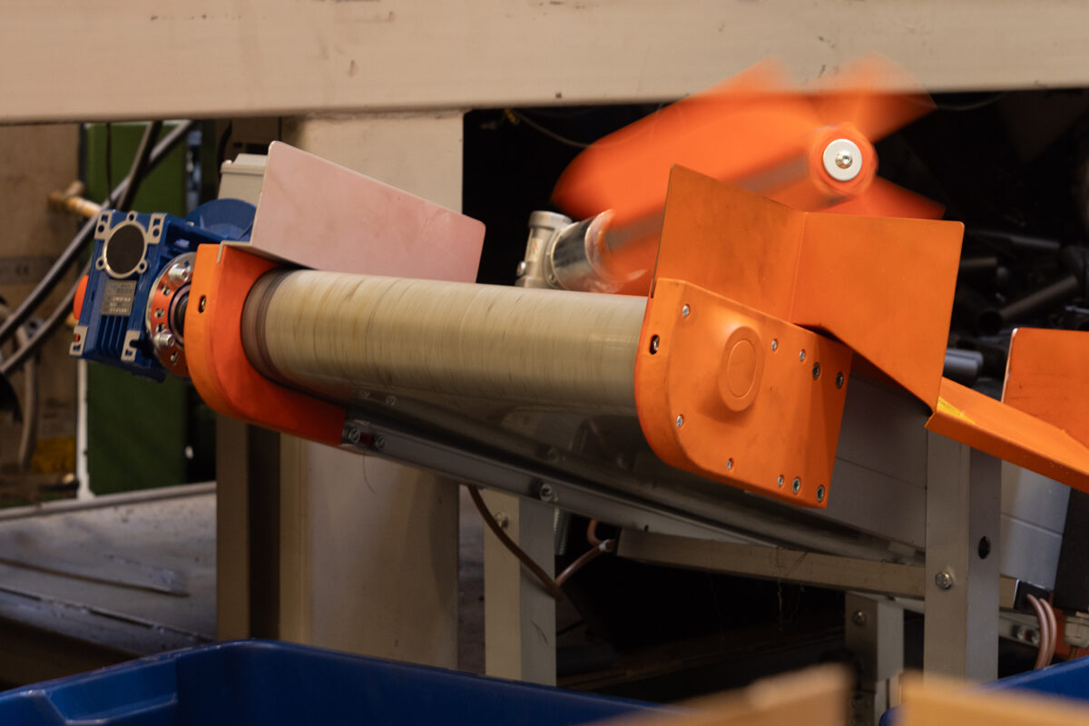 Tuotantolinja, oranssi syöttölaite pyörii vaudikkaasti